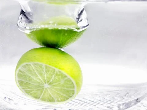 Whole Lime Dropping into Water Stock Photos