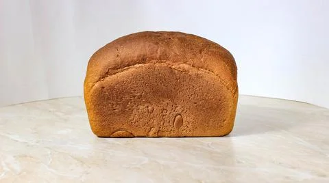 A whole loaf of black bread on the table. Homemade cakes. Stock Photos