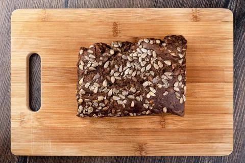 Whole loaf of rustic rye bread with sunflower seeds. Bread on a cutting board Stock Photos