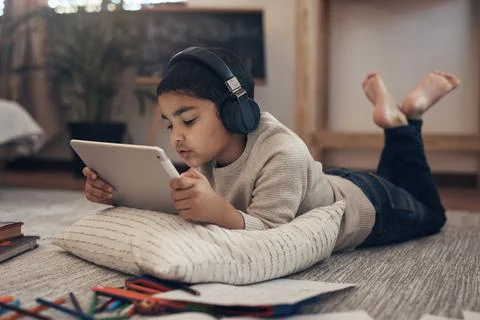 A whole lot of knowledge right under his nose. an adorable little boy using a Stock Photos