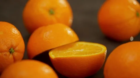 A whole orange falls on the table and spectacularly splits in half. Stock Footage 270735464