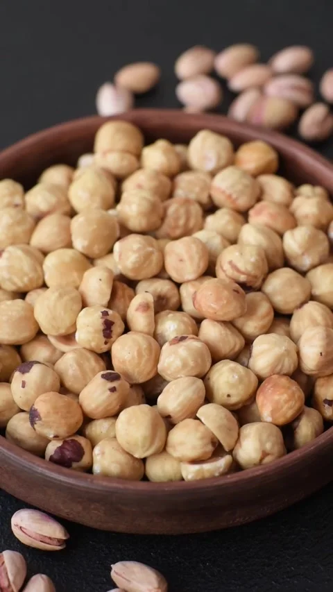 Whole peeled hazelnuts, roasted or raw, as an ingredient for healthy food. Hazel Video stock 329388375