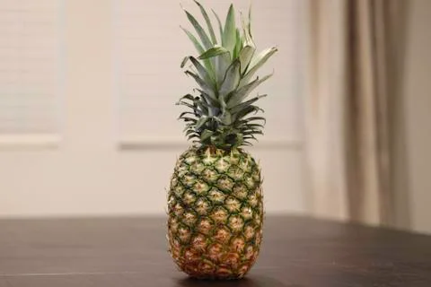Whole Pineapple sitting on table  Stock Photos