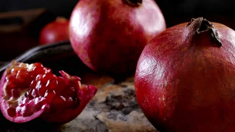 Whole pomegranate fruit rotating on a table Stock Footage 165340114