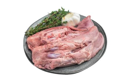 Whole raw uncooked lamb mutton tongue offal arranged on plate with herbs an.. Stock Photos