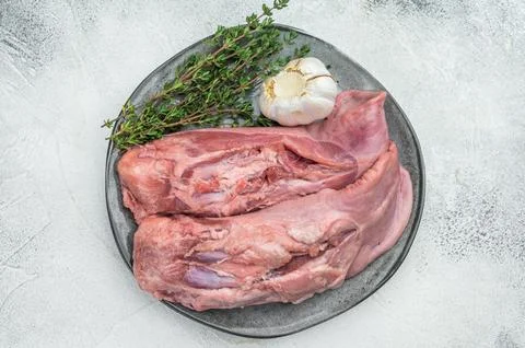 Whole raw uncooked lamb mutton tongue offal arranged on plate with herbs an.. Stock Photos
