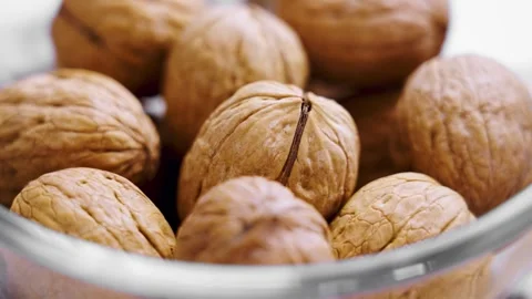 Whole raw walnuts with nutshells in glass bowl. Stock Footage 308926004