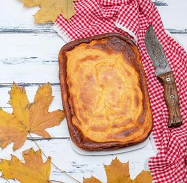 Whole rectangular pie of cottage cheese and pumpkin on a white wooden table, 스톡 사진