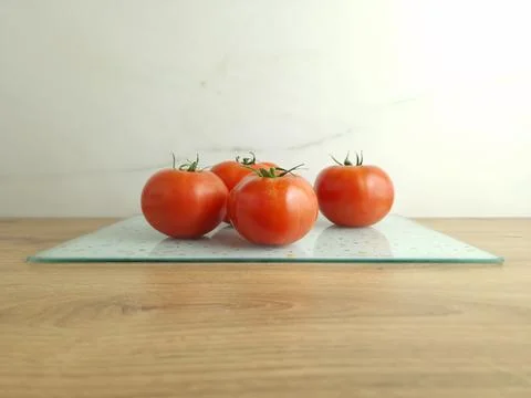 Whole red tomatoes on table Stock Photos