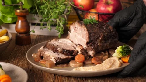 Whole roast pork neck. The cook turns the dish while lifting the plate. Stock Footage