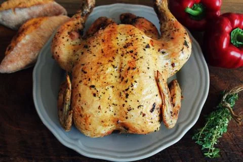 Whole roasted chicken on rustic table Stock Photos