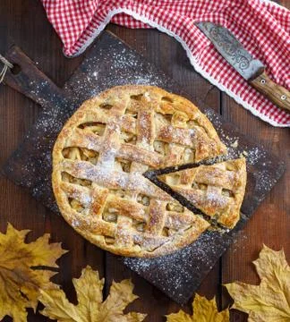 Whole round apple pie on a rectangular old brown board 스톡 사진