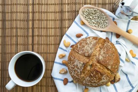 Whole rye bread, mixed nuts and sunflower seeds on white cloth with stripe wi Stock Photos
