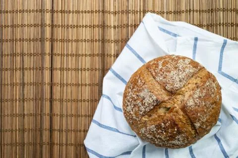Whole rye bread placed on white cloth with blue stripe. Stock Photos
