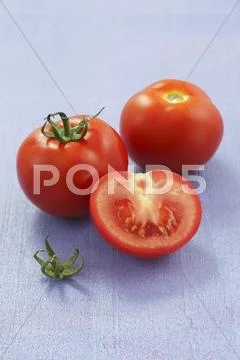 Whole tomatoes and a tomato half Stock Photos