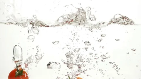 Whole Tomatoes Falling Through Water. Видео 72450069