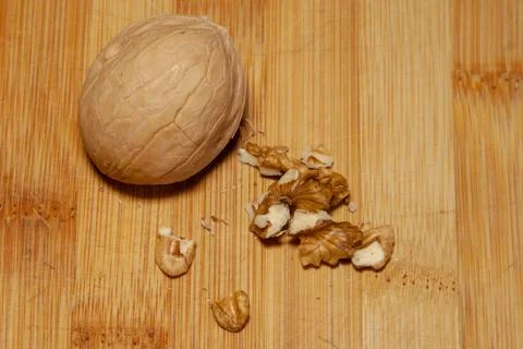 A whole walnut next to a split one on a light background 库存照片