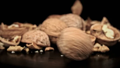 Whole Walnut Rolls in Slow Motion Against a Background of Pile of Nuts in a Loop Stock Footage 201075749