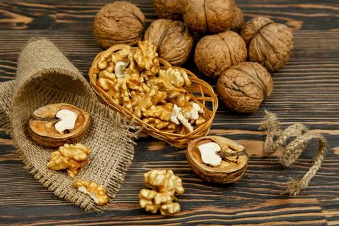 Whole walnuts and kernels on the table Stock Photos