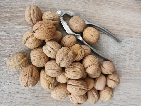 Whole walnuts and nutcracker Stock Photos