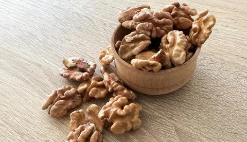 Whole walnuts and split on table. kernels of walnuts are dried and ready to eat Stock Photos