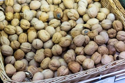 Whole walnuts with brown nutshells on retail market closeup Stock Photos