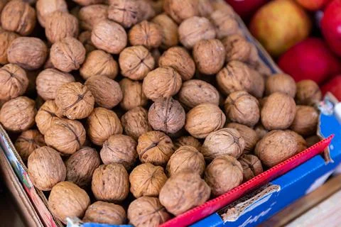 Whole walnuts with brown nutshells on retail market closeup Stock Photos