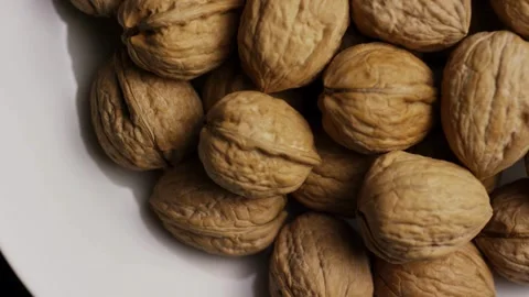 Whole walnuts with brown shells rotating top down view Stock Footage 327829594