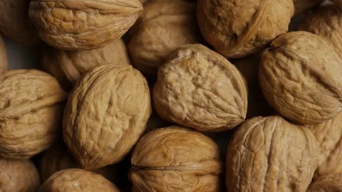 Whole walnuts with brown shells rotating top down view Video stock 327829698