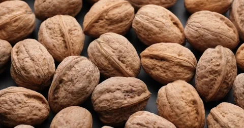 Whole walnuts close-up on rotating platform Stock Footage 243420092
