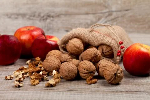 Whole walnuts, kernels and apples on the table Foto stock