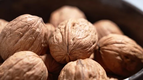 Whole walnuts in shell filling ceramic bowl Stock Footage 330420770