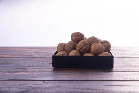 Whole walnuts on wooden table, side view on white background. Healthy nuts and Stock Photos