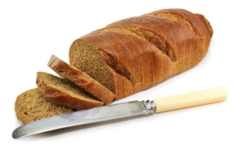 Whole wheat bread and table knife isolated on a white background Stock Photos