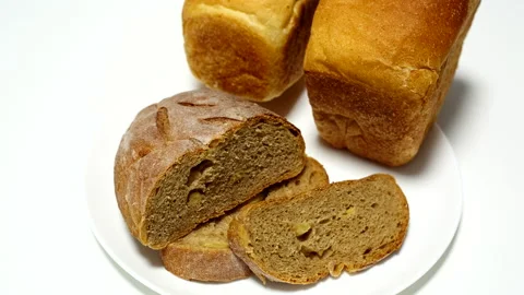 Whole wheat bread closeup on white plate - horizontal panning Stock Footage 139069175