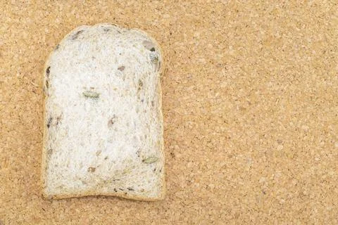 Whole wheat bread slice have rice grain on wood. Stock Photos