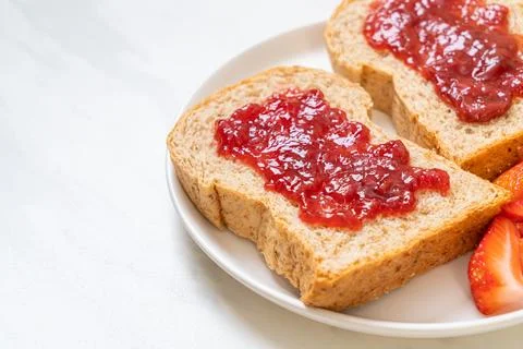 Whole wheat bread with strawberry jam and fresh strawberry Stock Photos