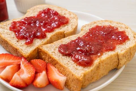 Whole wheat bread with strawberry jam and fresh strawberry Stock Photos