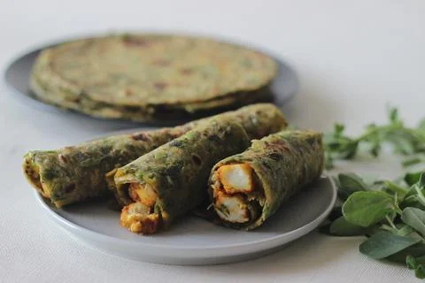 Whole wheat methi thepla rolls with paneer capsicum filling and a bowl of mas 스톡 사진