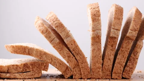 Whole wheat multigrain bread sliced falling on wooden table. Stock Footage 165342167