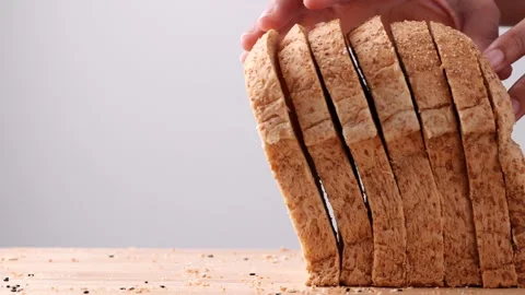 Whole wheat multigrain bread sliced falling on wooden table. Stock Footage 165342301