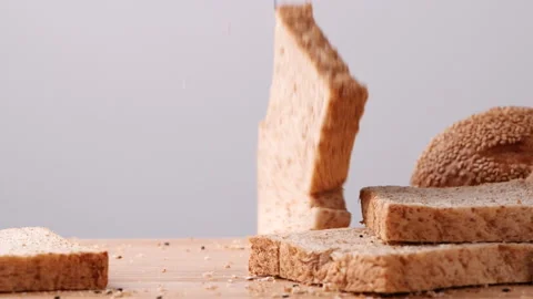 Whole wheat multigrain bread sliced falling on wooden table. Stock Footage 165342413
