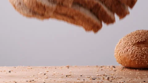 Whole wheat multigrain bread sliced falling on wooden table. Stock Footage 165342518