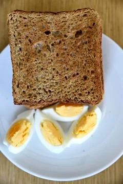 Whole wheat slice toasted bread with sliced boiled egg on the white plate for Foto stock