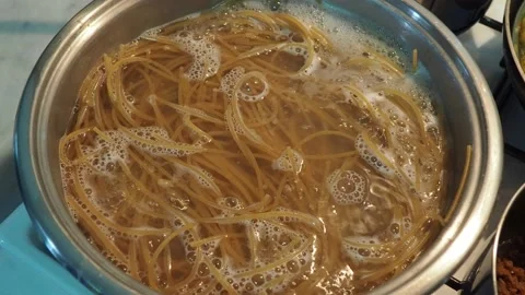 Whole wheat spaghetti pasta is boiling in a steel pot Stock Footage 141469282
