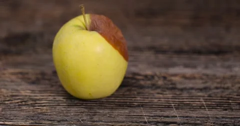 A whole yellow apple with a large orange spot during rotting, one rotting apple Stock Footage 327649776