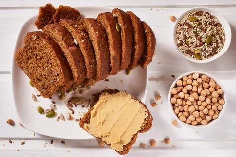 Wholegrain bread with chickpea paste on a white plate and a cup of coffee on Stock Photos