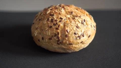 Wholegrain bread roll with seeds close up dark background video 스톡 동영상 318844477
