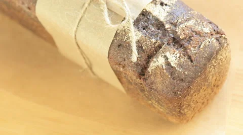 Wholegrain rye bread with twine bow on a wooden board Stock Footage 64769246