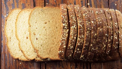 Wholegrain sliced organic bread composed of oats and flax seeds on wooden tab Stock Footage 104580653